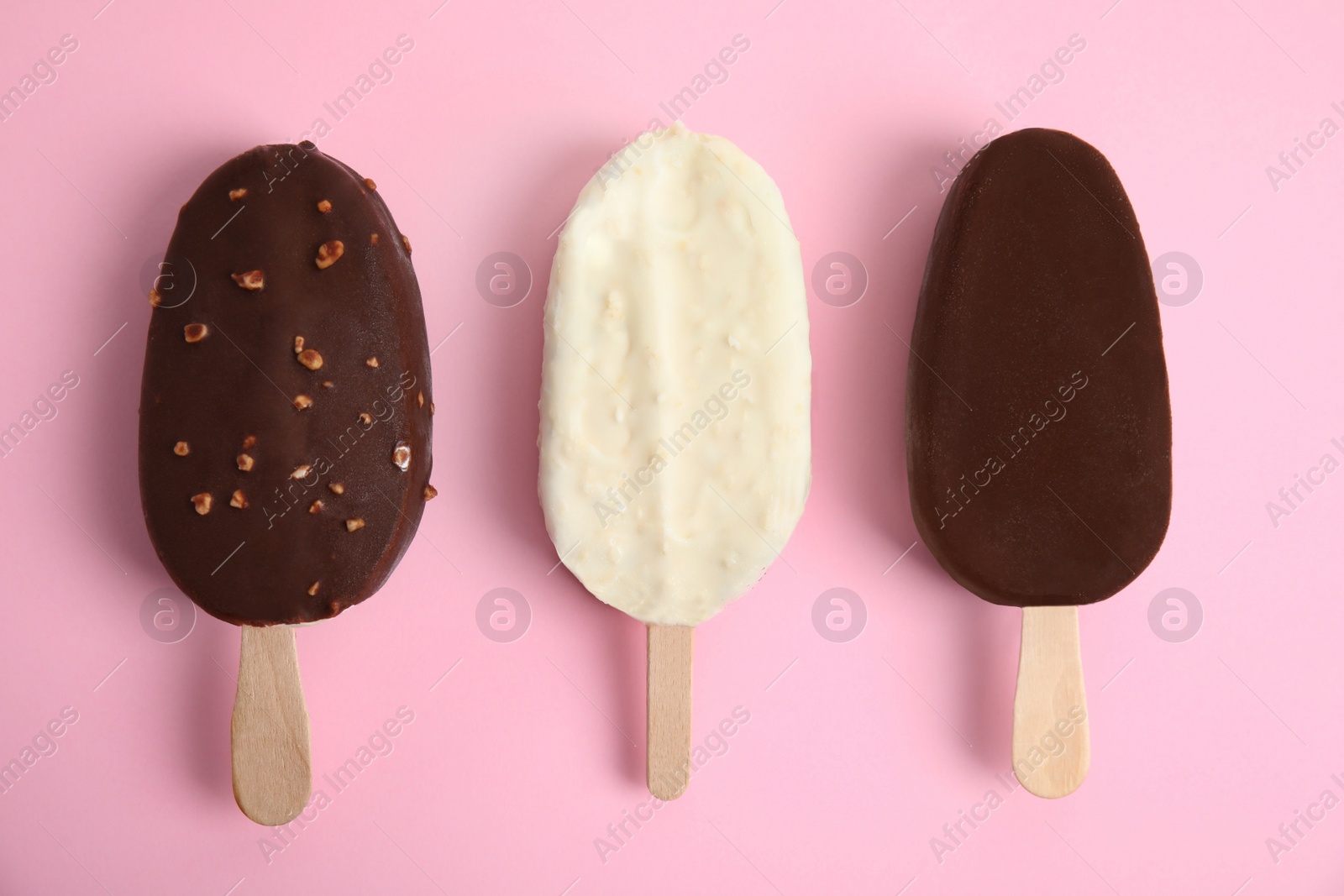 Photo of Glazed ice cream bars on pink background, flat lay