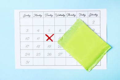 Photo of Calendar and menstrual pads on color background, top view. Gynecological care