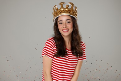 Photo of Beautiful young woman with inflatable crown and . Beauty contest on grey background