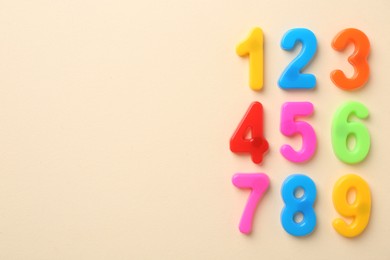 Photo of Colorful numbers on beige background, flat lay. Space for text