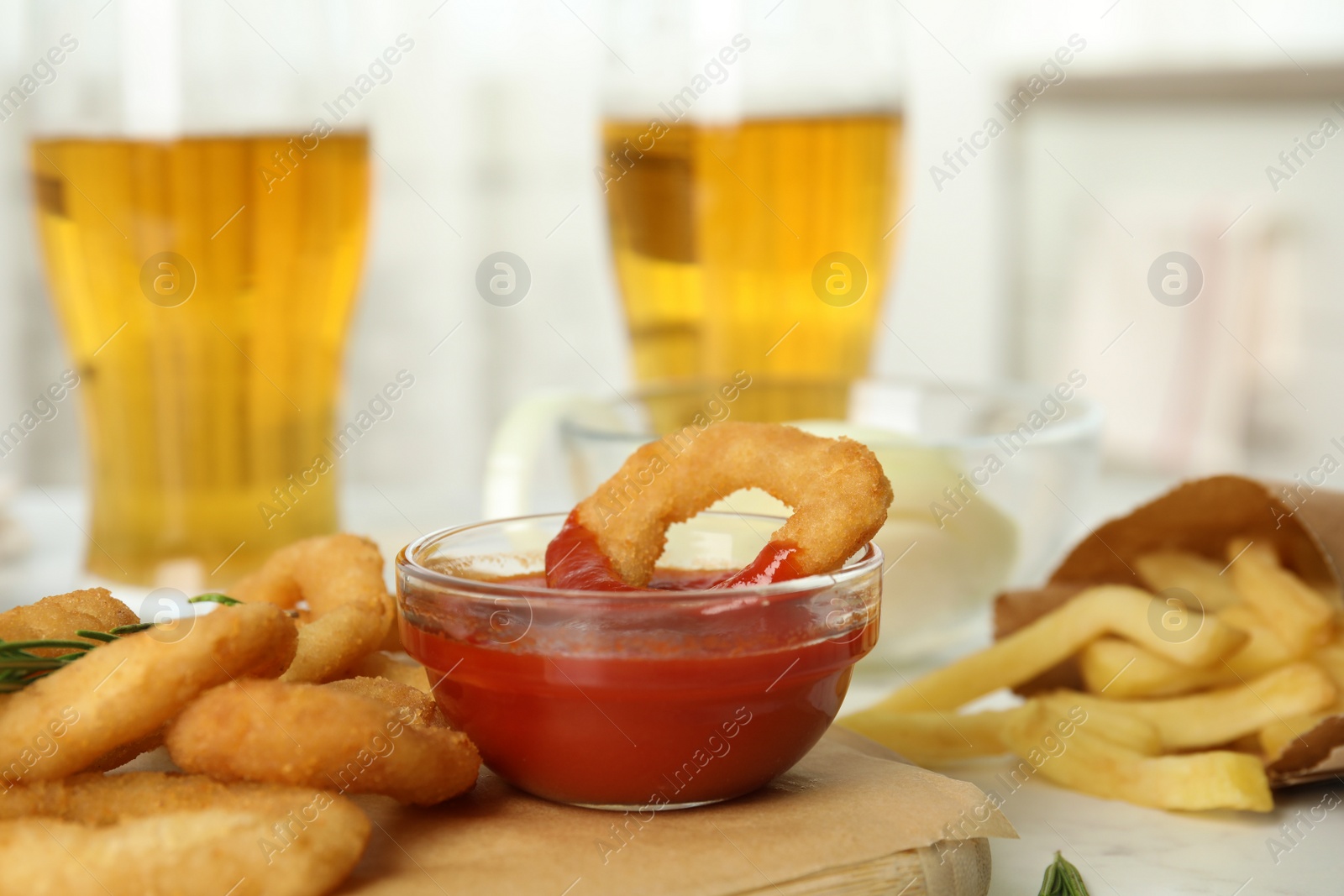 Photo of Fried onion rings with sauce served on table