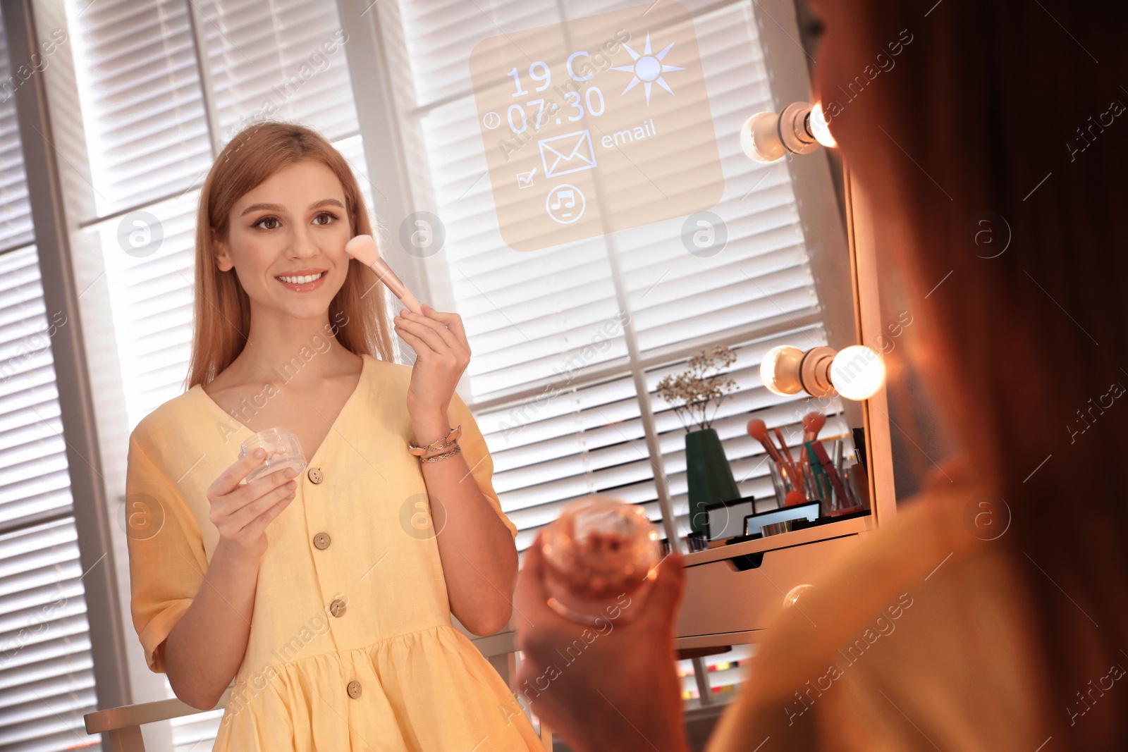 Image of Beautiful young woman applying makeup near smart mirror in dressing room