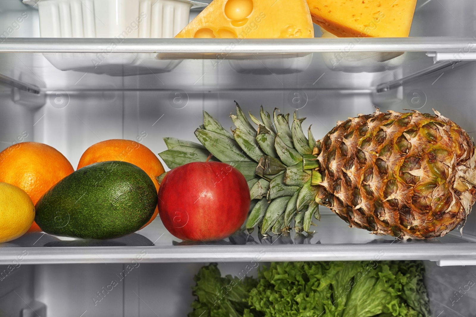 Photo of Different fresh fruits on shelf in refrigerator