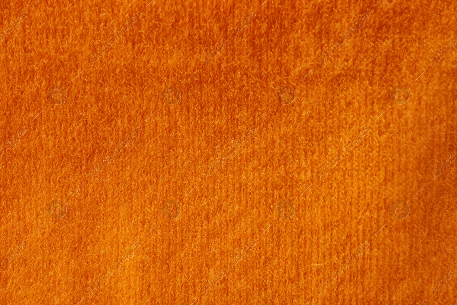 Photo of Orange knitted fabric texture as background, closeup