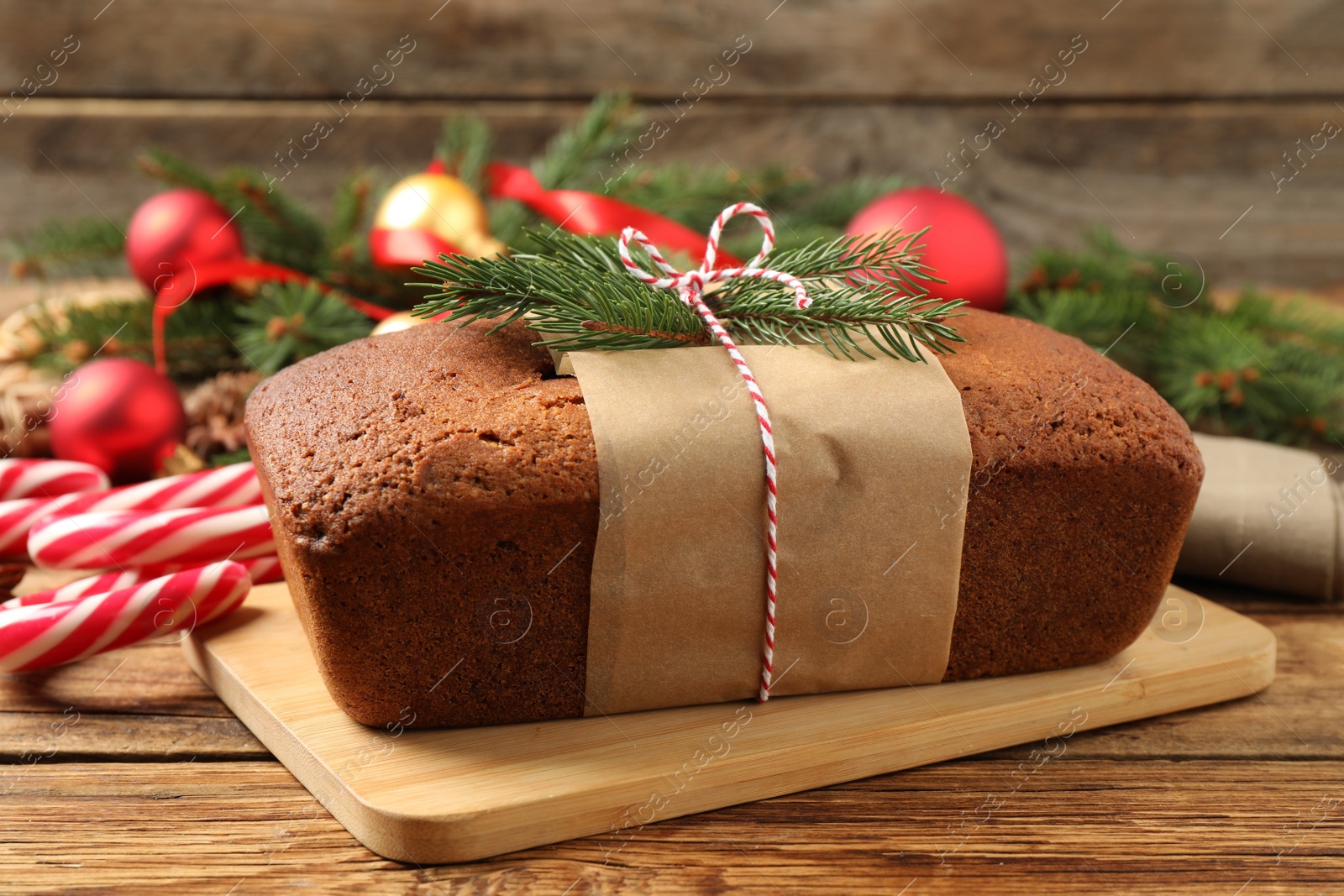 Photo of Delicious gingerbread cake, candy canes and Christmas decor on wooden table