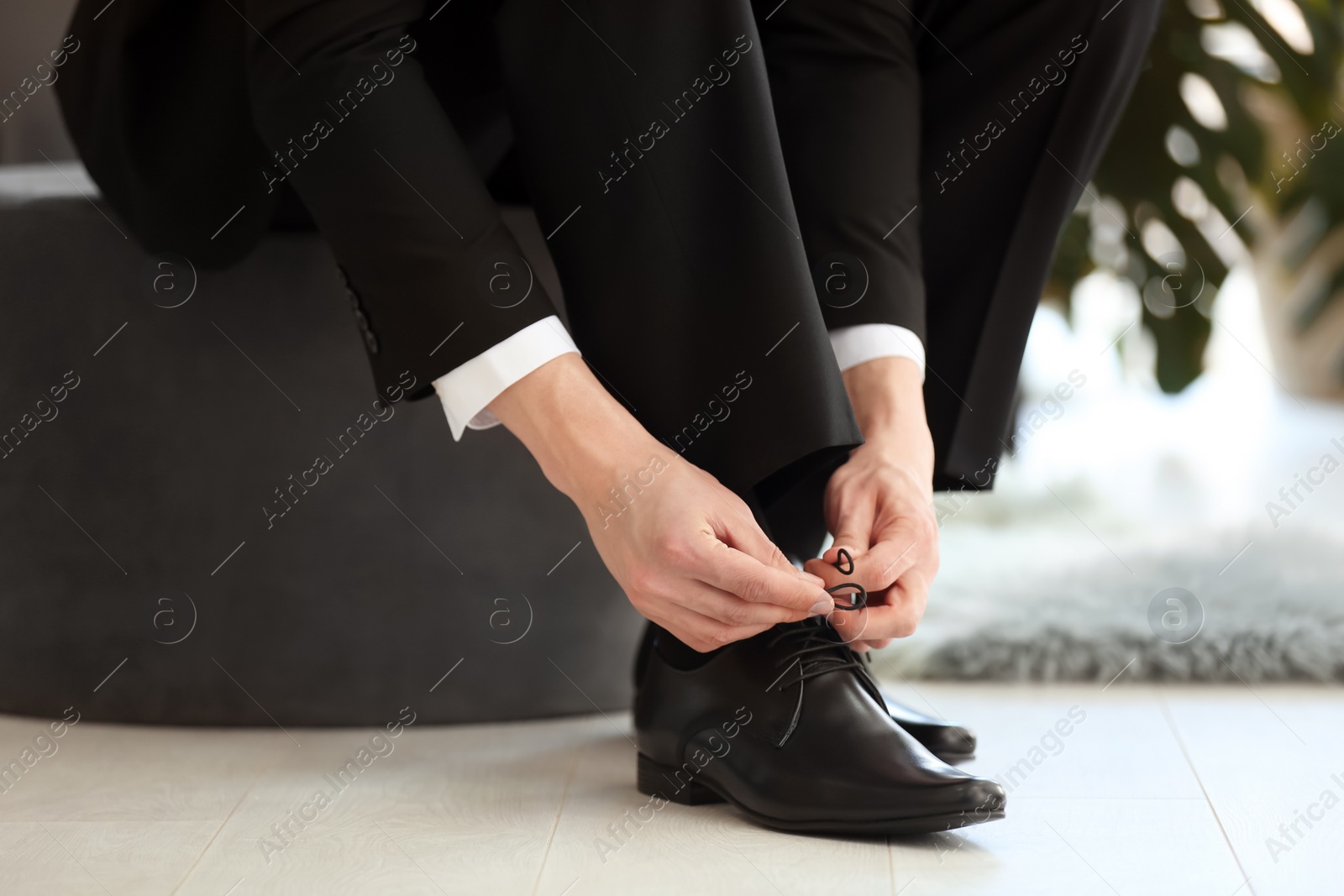 Photo of Young man trying on shoes in store