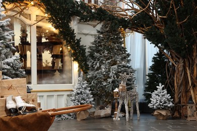 Beautiful Christmas trees, many gift boxes, skates and festive decor indoors. Interior design