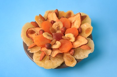 Photo of Mixed dried fruits and nuts on light blue background, closeup