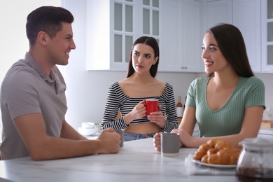 Unhappy woman feeling jealous while couple spending time together in kitchen