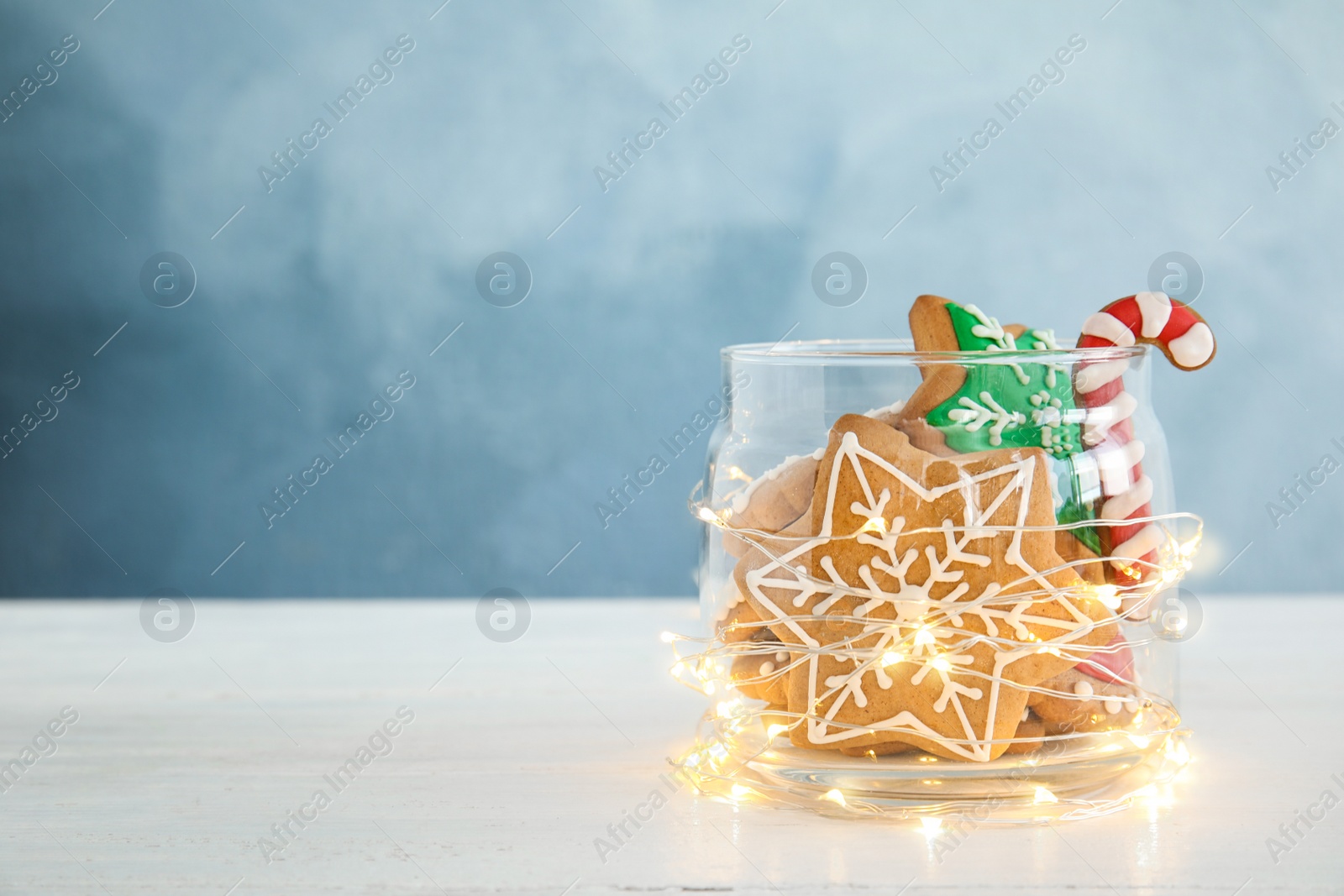 Photo of Glass jar with tasty homemade Christmas cookies on table