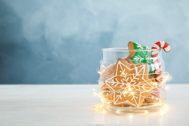 Photo of Glass jar with tasty homemade Christmas cookies on table