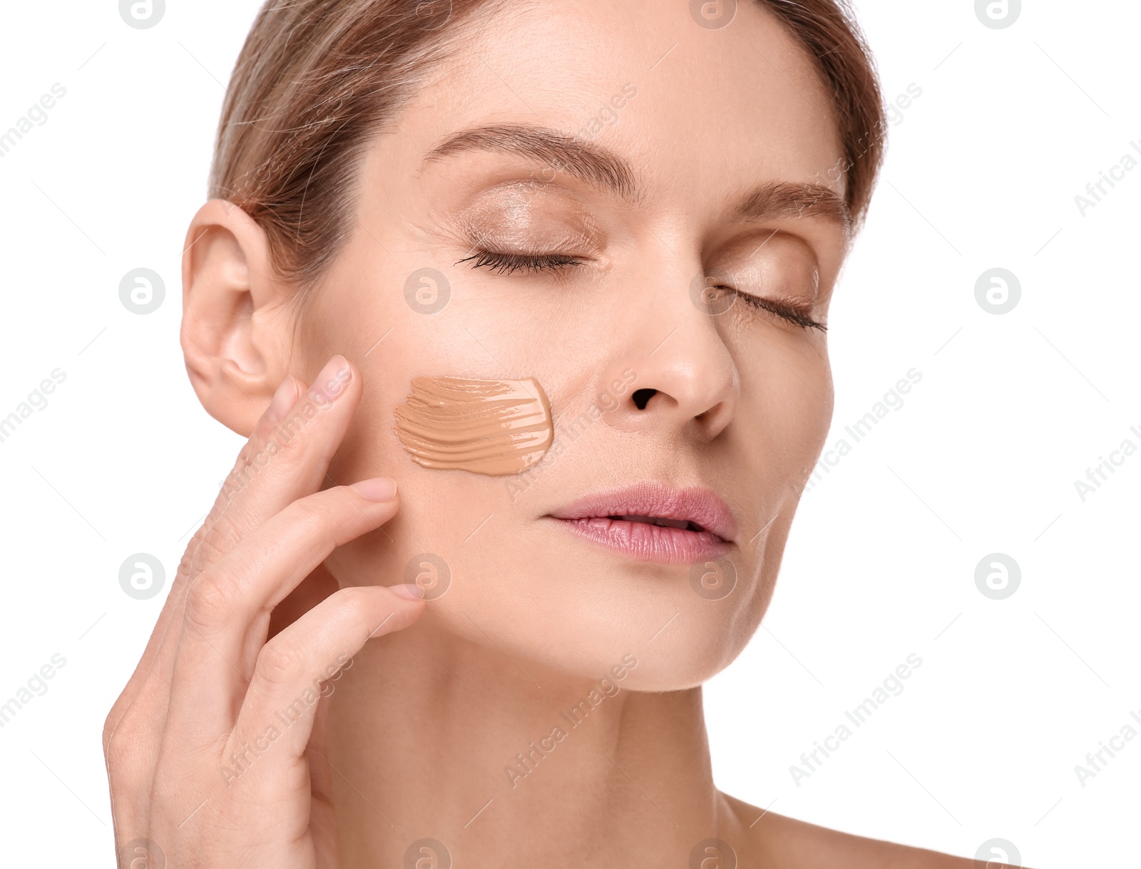 Photo of Woman with swatch of foundation on face against white background