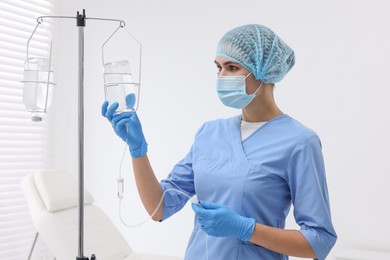 Photo of Nurse setting up IV drip in hospital