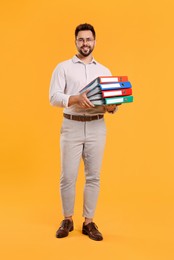 Happy man with folders on orange background