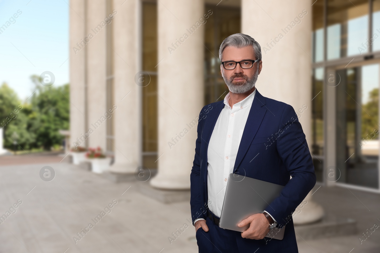 Image of Successful lawyer with laptop near building outdoors, space for text