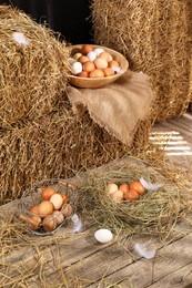 Fresh chicken eggs and dried straw bales in henhouse