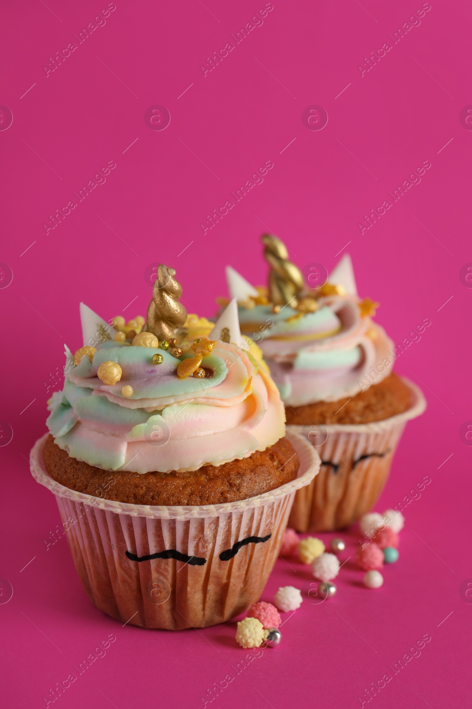 Photo of Cute sweet unicorn cupcakes on pink background