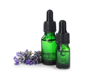 Photo of Bottles with natural lavender oil and flowers on white background