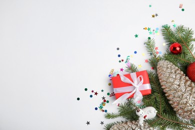 Photo of Christmas greeting card with space for text. Flat lay composition of fir tree branches and festive decor on white background