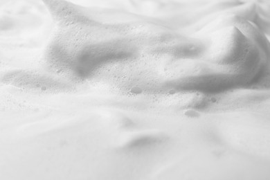 Photo of Foam as background, closeup. Face cleanser, skin care cosmetic