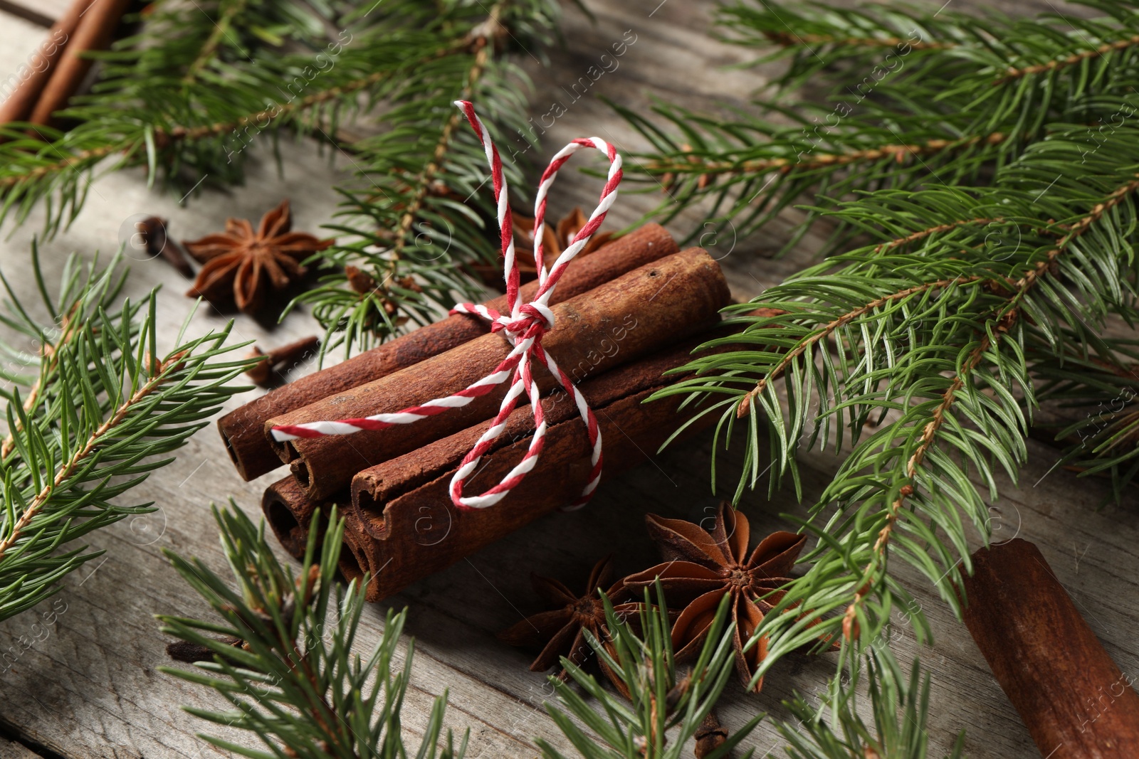 Photo of Different spices and fir branches on wooden table, above view