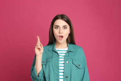 Portrait of emotional young woman on pink background