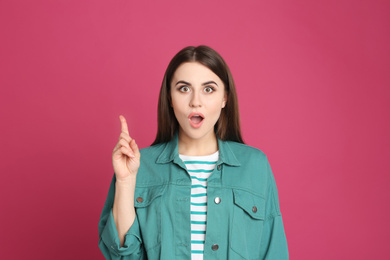 Photo of Portrait of emotional young woman on pink background