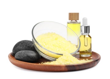 Photo of Yellow sea salt in bowl, spa stones and cosmetic products isolated on white