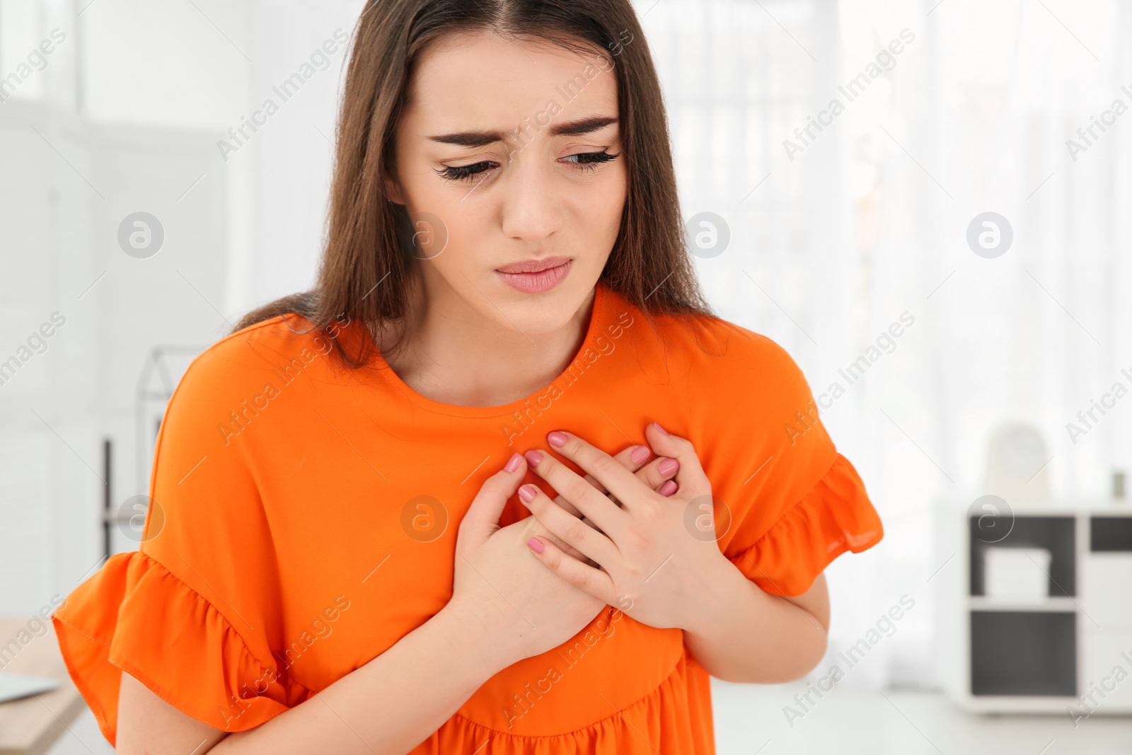 Photo of Young woman suffering from heart attack at home