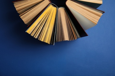 Photo of Hardcover books on blue background, flat lay