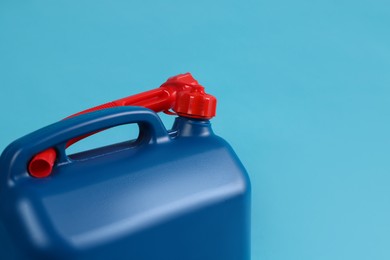 Photo of New plastic canister on light blue background, closeup. Space for text