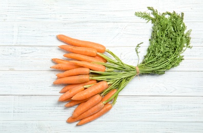 Ripe carrots on wooden background, top view