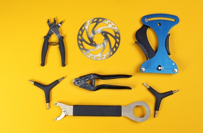 Photo of Set of different bicycle tools and part on color background, flat lay