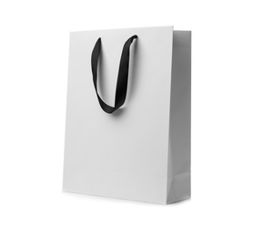 Photo of Paper shopping bag with ribbon handles on white background. Mockup for design