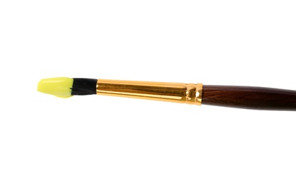 Brush with color paint on white background, top view