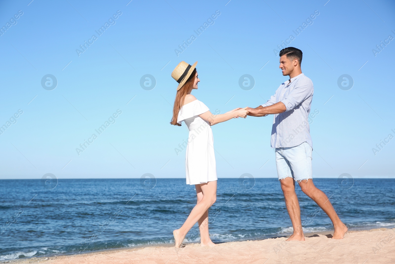 Photo of Lovely couple spending time together on beach. Space for text