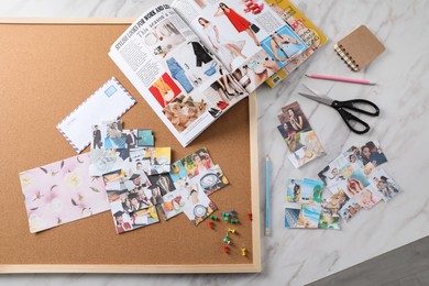 Photo of Flat lay composition with different photos, magazines and stationery on white marble background. Creating vision board