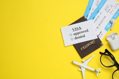 Flat lay composition with passport, toy plane and tickets on yellow background, space for text. Visa receiving