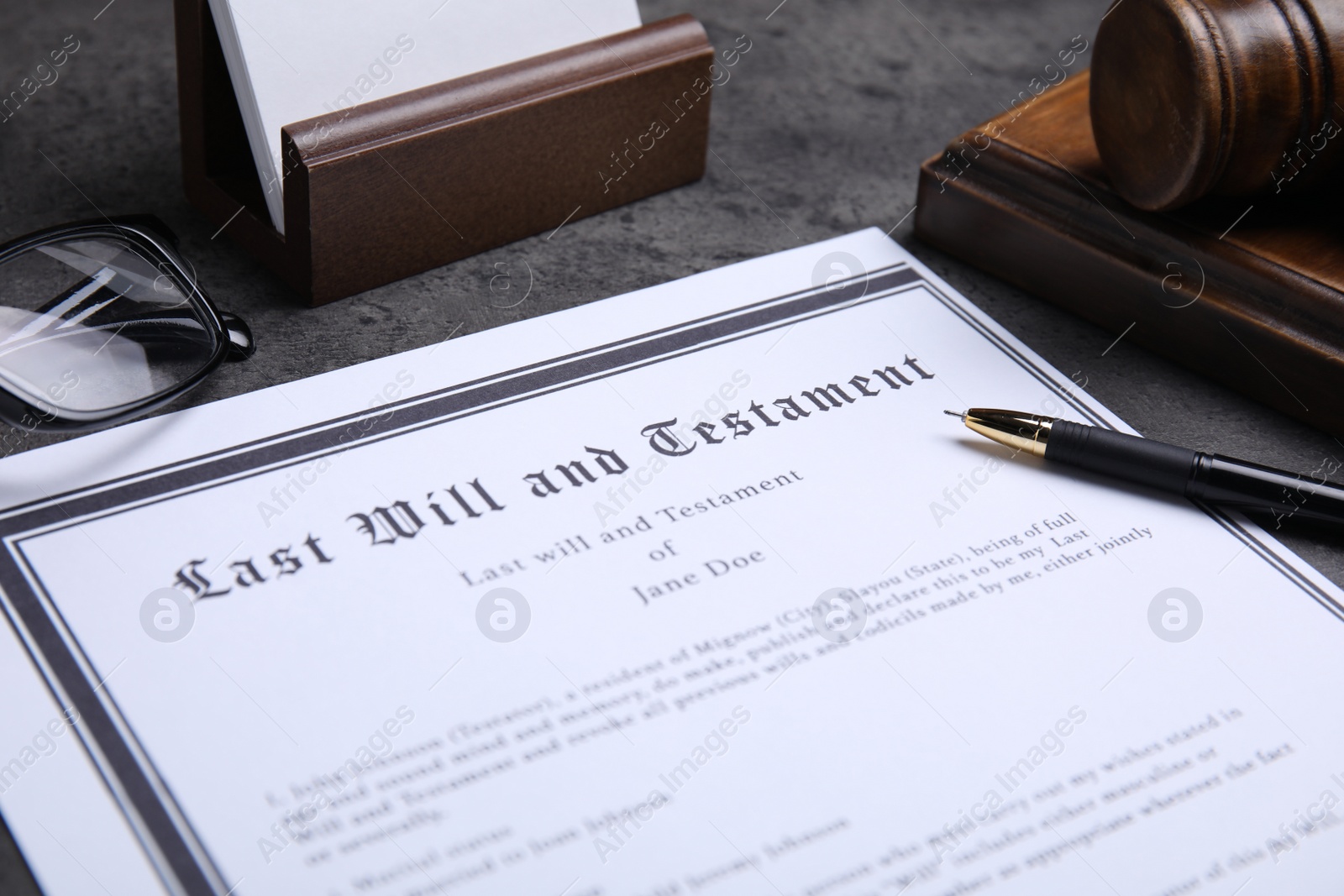 Photo of Last will and testament with pen on grey table, closeup