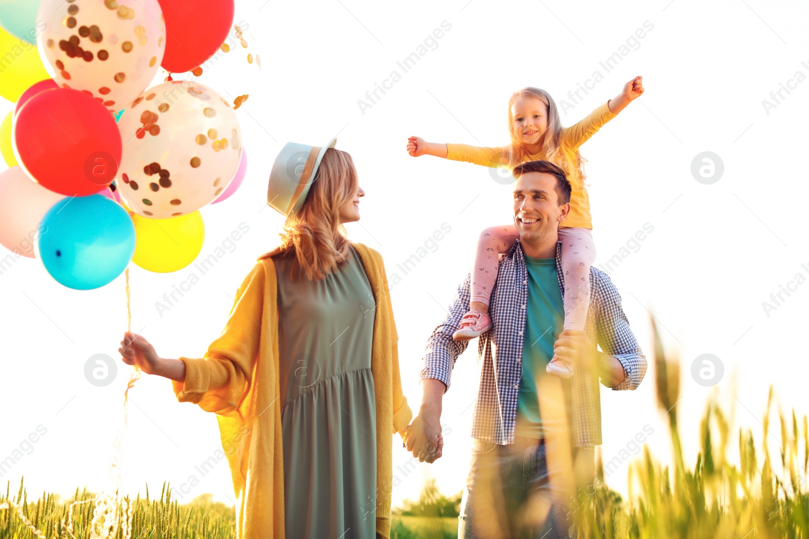 Photo of Happy family with colorful balloons outdoors on sunny day