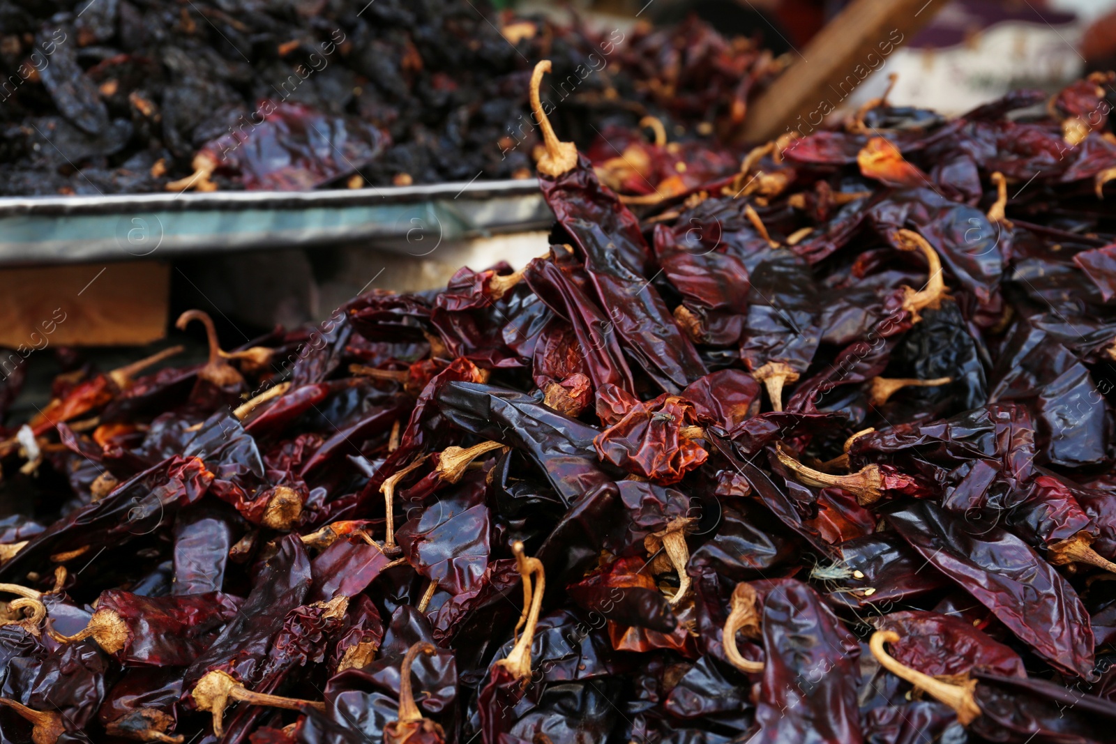 Photo of Heap of dried Serrano peppers on counter at market, closeup