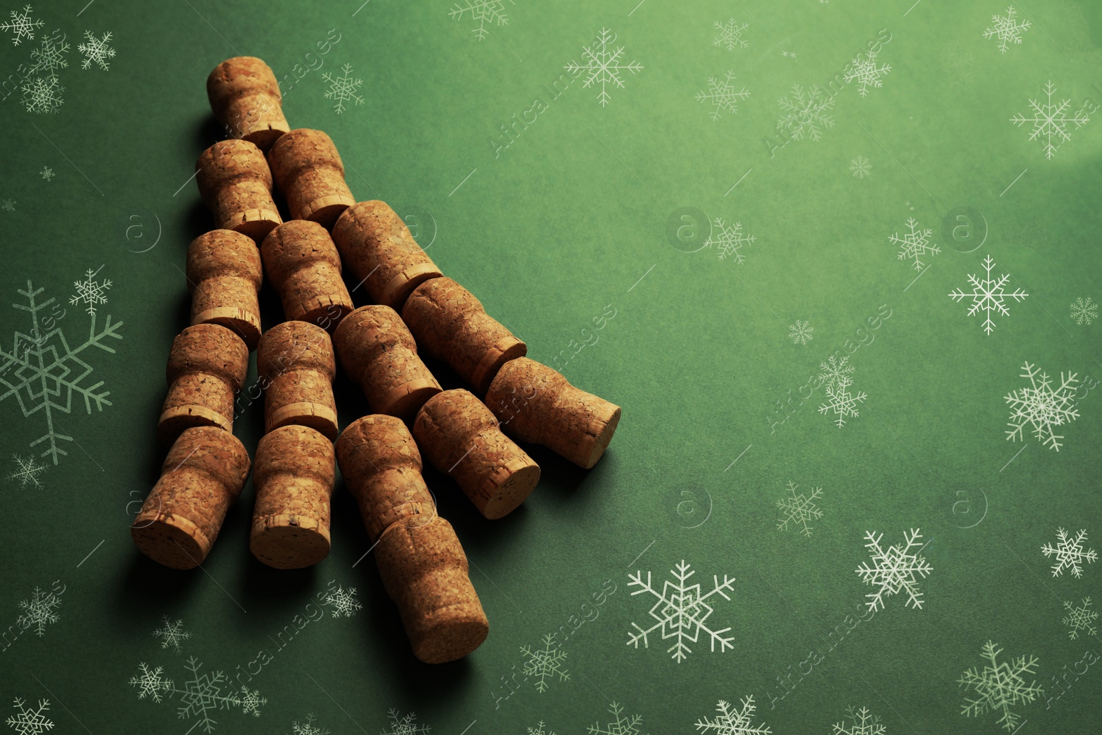 Image of Christmas tree made of wine corks on green background. Space for text
