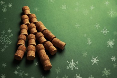 Image of Christmas tree made of wine corks on green background. Space for text