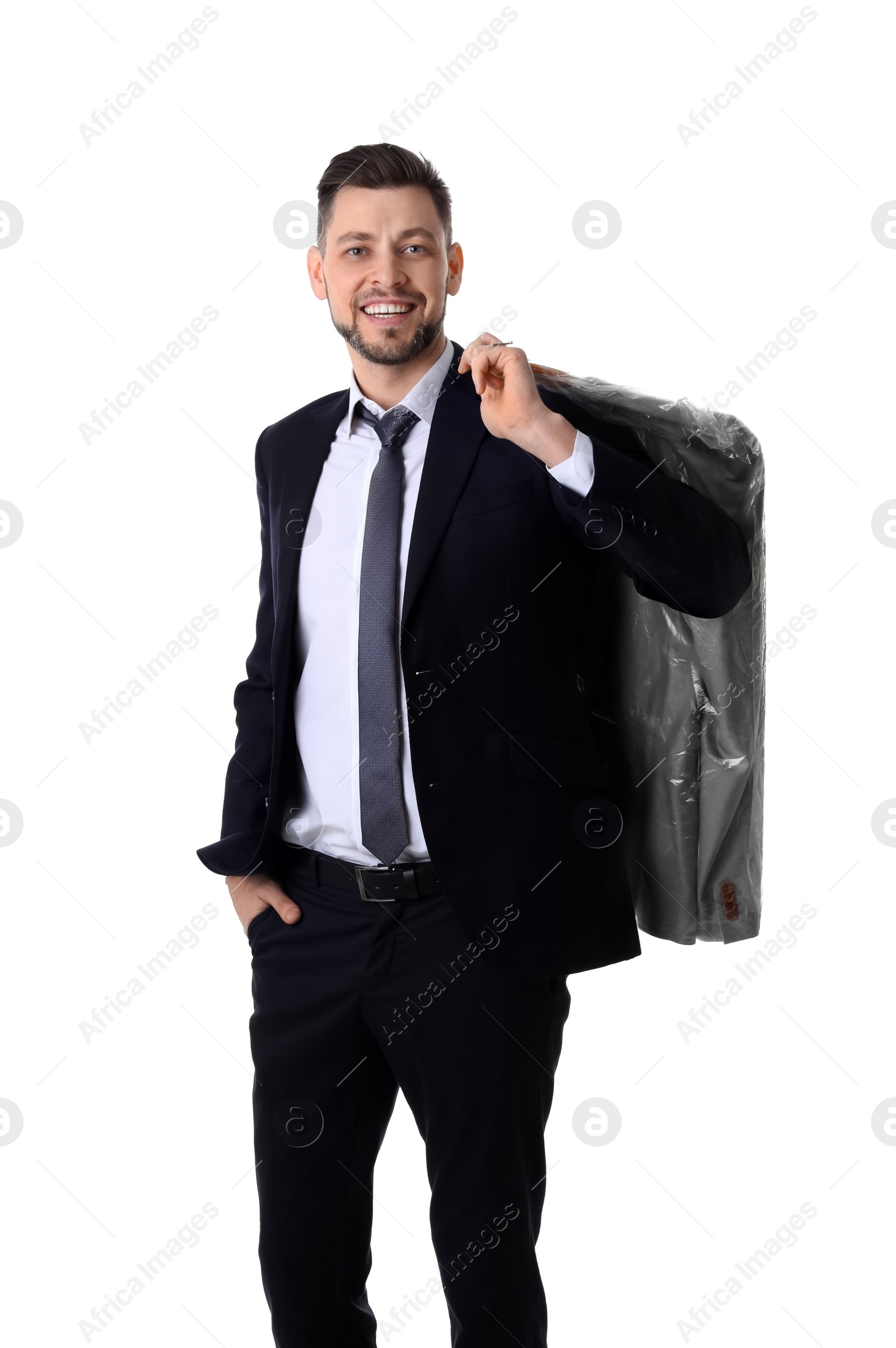 Photo of Young businessman holding hanger with jacket in plastic bag on white background. Dry-cleaning service