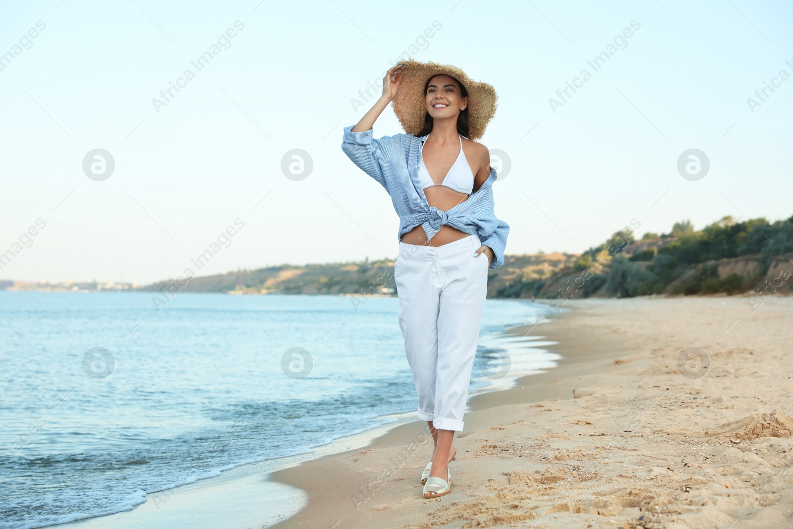 Photo of Beautiful young woman in straw hat on beach