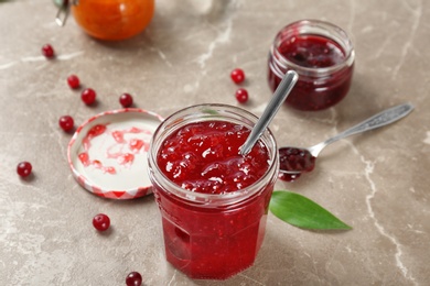 Photo of Jar with tasty sweet jam on table