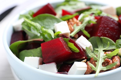 Photo of Delicious beet salad with feta cheese in bowl, closeup