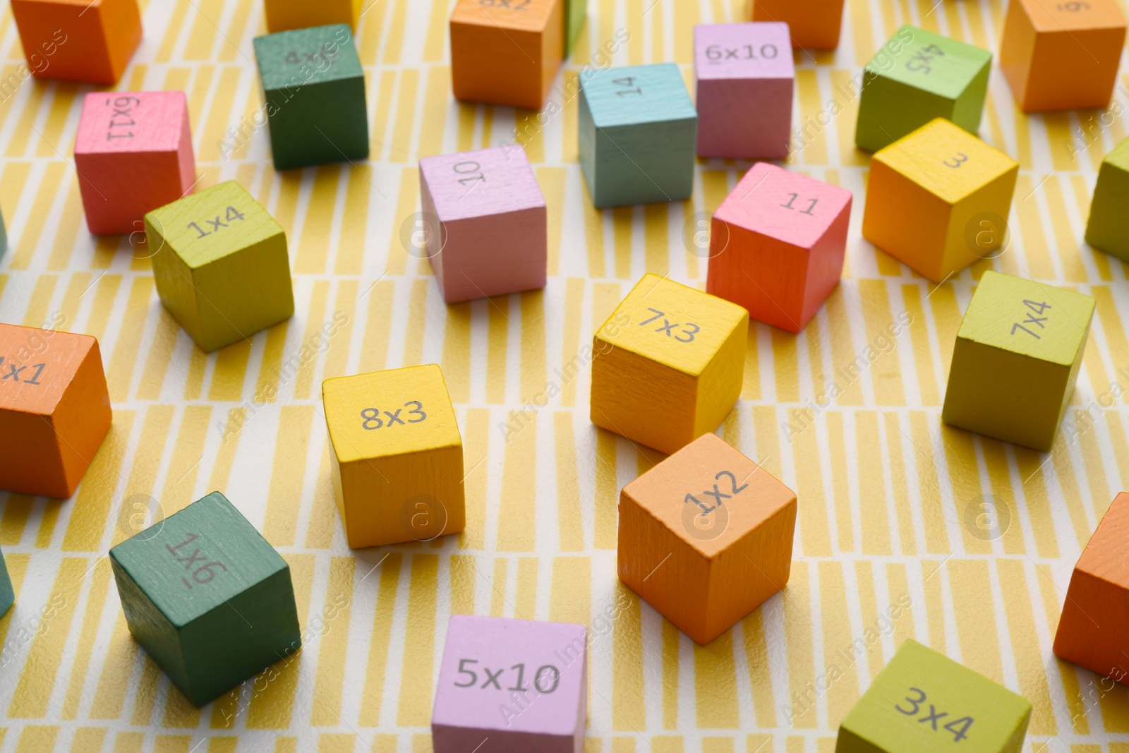 Photo of Colorful cubes with numbers and multiplications on yellow background