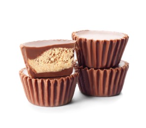 Cut and whole delicious peanut butter cups on white background