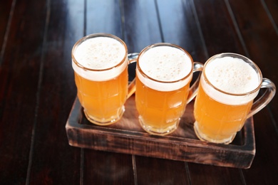 Photo of Glasses of tasty beer on wooden table